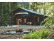 Beautiful home exterior with a fire pit area, surrounded by lush greenery, ideal for outdoor entertaining at 665 Lonach Ln, Roxboro, NC 27574