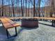 Outdoor fire pit with wooden benches and gravel area, perfect for enjoying lake views at 665 Lonach Ln, Roxboro, NC 27574