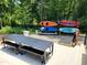 Outdoor recreational area with a table, benches, kayaks, and paddle boards for lakeside activities at 665 Lonach Ln, Roxboro, NC 27574