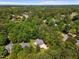 Lush aerial view of a home nestled among mature trees, with a manicured lawn and surrounding greenery at 6819 Rainwater Rd, Raleigh, NC 27615