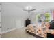 Bright bedroom with a ceiling fan, large windows, and cozy floral bedding, creating a relaxing retreat at 6819 Rainwater Rd, Raleigh, NC 27615