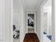 Hallway with dark wooden floors leading to a workout room and full bathroom at 6819 Rainwater Rd, Raleigh, NC 27615