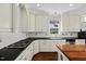 Well-appointed kitchen with black countertops, white cabinets, and a gas cooktop at 6819 Rainwater Rd, Raleigh, NC 27615