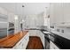 Spacious kitchen with stainless appliances, a wood island, and white cabinetry at 6819 Rainwater Rd, Raleigh, NC 27615