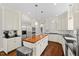 Open kitchen featuring stainless steel appliances, a butcher block island and white cabinets at 6819 Rainwater Rd, Raleigh, NC 27615