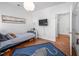 Well-lit bedroom featuring a blue bed frame, leopard-print rug, and a mounted television at 708 Copperline Dr # 101, Chapel Hill, NC 27516
