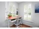 Bright home office featuring a modern desk setup and natural light from shuttered windows at 708 Copperline Dr # 101, Chapel Hill, NC 27516