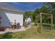 Spacious backyard featuring outdoor dining, a cozy seating area, a swing, and lush landscaping creating a relaxing outdoor oasis at 715 Barlang Cir, Fuquay Varina, NC 27526