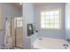 Bathroom featuring bathtub, glass door shower, and a large window at 715 Barlang Cir, Fuquay Varina, NC 27526