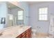 Bright bathroom featuring double sinks, large mirror, and vanity lighting at 715 Barlang Cir, Fuquay Varina, NC 27526