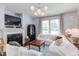Cozy living room featuring a fireplace, modern lighting fixture, and plush white seating at 715 Barlang Cir, Fuquay Varina, NC 27526