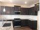 Contemporary kitchen with dark cabinets, stainless steel appliances, and granite countertops at 718 Colby Pl, Durham, NC 27713