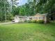 Ranch-style home featuring a well-manicured lawn, mature trees, and a two-car garage at 725 Van Thomas Dr, Raleigh, NC 27615