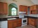 Well-lit kitchen featuring wooden cabinets, laminate countertops, and white appliances at 725 Van Thomas Dr, Raleigh, NC 27615