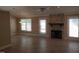Open living room featuring a stone fireplace, wood floors, and windows for natural light at 725 Van Thomas Dr, Raleigh, NC 27615