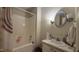 Cozy bathroom with a shower-tub combo and a white sink vanity featuring a round mirror at 7312 Ray Rd, Raleigh, NC 27613