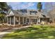 Backyard view of a brick home with a sunroom, stone walkway, and outdoor seating at 7420 Heartland Dr, Wake Forest, NC 27587