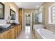 Bright bathroom with double sink, bathtub, walk-in shower, and natural light at 7420 Heartland Dr, Wake Forest, NC 27587