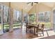 Bright sunroom featuring brick accents, tile floor, ceiling fan, and views of the landscaped backyard at 7420 Heartland Dr, Wake Forest, NC 27587