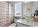 Bright bathroom featuring a glass bowl sink, and a window offering serene views at 7829 Acc Blvd, Raleigh, NC 27617
