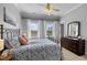 Comfortable bedroom with an iron bed frame, ceiling fan, and ample natural light from two windows at 7829 Acc Blvd, Raleigh, NC 27617