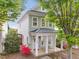 Charming two-story home featuring a welcoming front porch with rocking chairs and beautiful landscaping at 7829 Acc Blvd, Raleigh, NC 27617
