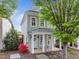 Charming two-story home featuring a welcoming front porch with rocking chairs and beautiful landscaping at 7829 Acc Blvd, Raleigh, NC 27617