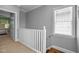 Upstairs hallway with neutral walls, white trim, and natural light from a window at 7829 Acc Blvd, Raleigh, NC 27617