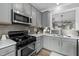 Close up of a kitchen featuring a gas range, grey backsplash, and grey cabinetry at 7829 Acc Blvd, Raleigh, NC 27617
