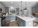 Modern kitchen featuring gray cabinets, an island with quartz countertop, and stainless steel appliances at 7829 Acc Blvd, Raleigh, NC 27617