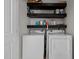 Functional laundry room with a washer, dryer, and shelving for storing cleaning supplies at 7829 Acc Blvd, Raleigh, NC 27617