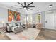 Bright living room featuring a gray sofa, two chairs, and windows allowing plenty of natural light at 7829 Acc Blvd, Raleigh, NC 27617