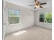 Bright, sunny bedroom with two windows, plush carpet, and a ceiling fan for added comfort at 7851 Allscott Way, Raleigh, NC 27612