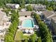 Aerial view of the community pool surrounded by lounge chairs, umbrellas and lush greenery at 7851 Allscott Way, Raleigh, NC 27612