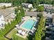 Aerial view of a community pool with lounge chairs and umbrellas surrounded by trees at 7851 Allscott Way, Raleigh, NC 27612