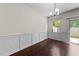 Formal dining room featuring wood floors, wainscoting and modern lighting fixtures at 7851 Allscott Way, Raleigh, NC 27612