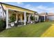 A covered back porch has ample seating and is surrounded by healthy green lawn and landscaping at 825 Flower Manor Dr, Wendell, NC 27591