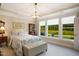 Bedroom with tray ceiling, chandelier and large windows providing a view of the backyard at 825 Flower Manor Dr, Wendell, NC 27591