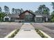 Front exterior of community clubhouse features ample parking and inviting entrance with crosswalk at 825 Flower Manor Dr, Wendell, NC 27591