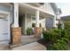 Inviting front porch with stone pillars, cozy seating, and well-maintained landscaping at 825 Flower Manor Dr, Wendell, NC 27591