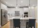 Bright kitchen with stainless steel appliances, white cabinets, large island and pendant lighting at 825 Flower Manor Dr, Wendell, NC 27591