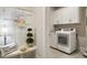 Inviting mudroom with white cabinetry, a bench, coat hooks and an adjacent laundry area at 825 Flower Manor Dr, Wendell, NC 27591