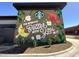 A vibrant Starbucks mural featuring bright colors, whimsical imagery, and an inspiring message, with professionally designed landscaping at 825 Flower Manor Dr, Wendell, NC 27591