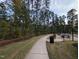 Paved walking path winding through a tranquil community park with mature trees at 825 Flower Manor Dr, Wendell, NC 27591