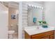 Bright bathroom features wood-tone vanity, mirror with lighting, and a view of toilet at 919 Orient St, Durham, NC 27701