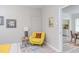 Bright bedroom features a stylish yellow armchair, side table, and colorful artwork at 919 Orient St, Durham, NC 27701