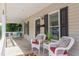 Inviting front porch with stylish seating, including wicker chairs and decorative pillows and plants at 919 Orient St, Durham, NC 27701