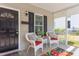 Charming front porch with wicker chairs, patterned cushions, black door, and decorative welcome mat at 919 Orient St, Durham, NC 27701