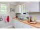 Well-lit kitchen featuring butcher block countertops, white cabinets, and a stainless steel sink at 919 Orient St, Durham, NC 27701