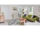 Bright living room featuring a green sofa, wood coffee table, fireplace, and neutral decor at 919 Orient St, Durham, NC 27701
